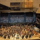 On stage at the Philharmonie de Paris, the Cambridge University Symphony Chorus is in the choir stalls wearing black tie concert outfits. The orchestra is on the stage in front